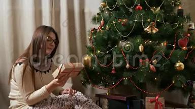 年轻、快乐、情绪化的女孩<strong>打开</strong>了一份神奇的圣诞礼物，一个装饰着圣诞树的<strong>礼盒</strong>